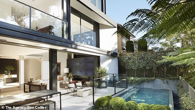 The open-plan living space opens up onto a manicured garden with a resort-style pool.